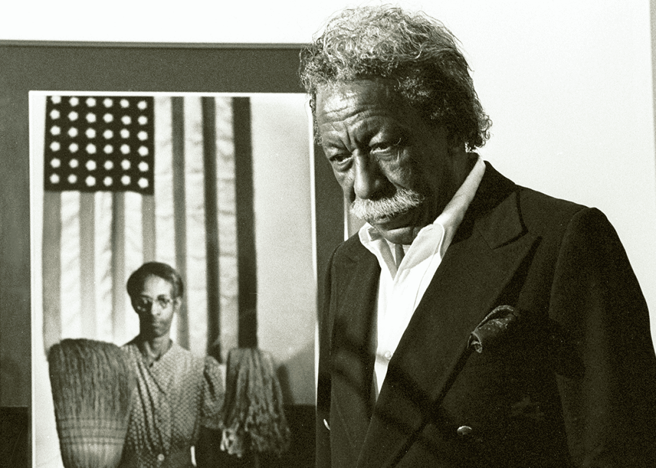 Gordon Parks Gordon Parks stands next to one of his most famous images 'American Gothic’.